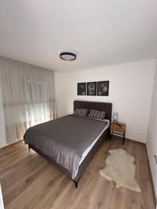 Un dormitorio con una cama grande y suelo de madera. en Art Residence, en Tuzla