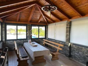 a room with a table and a bench and windows at Art Residence in Tuzla