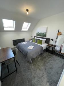 a bedroom with a bed and a table and windows at Brand New High Spec House with Parking & Wi-Fi By Home Away From Home - B in Newcastle under Lyme
