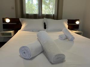 1 cama con 2 toallas y 2 almohadas en Artemis Airport Stay, en Artemida