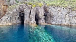 a body of water with a cave in a cliff at L'Isolana Case Vacanza Alloro 3 in Ponza