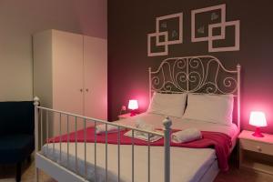 a bedroom with a bed with pink lights on it at Electra Apartments & Studios 2 in Keramoti