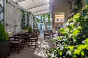 an outdoor patio with tables and chairs and plants at Electra Apartments & Studios 2 in Keramotí