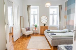 a bedroom with two beds and a chair in it at Premium Suites Vienna - City Stay in Vienna