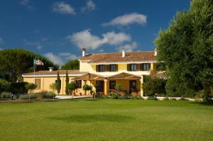 une grande maison jaune avec une grande cour dans l'établissement Is Benas Country Lodge, à San Vero Milis