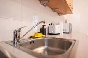 a kitchen counter with a sink in a kitchen at Premium Suites Vienna - City Stay in Vienna