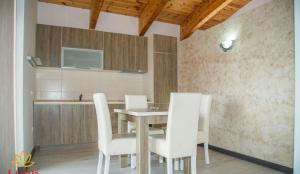 une salle à manger avec une table et des chaises blanches dans l'établissement Lotos - family stan, à Bar