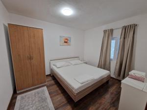 a small bedroom with a bed and a cabinet at Apartment Gligora in Mandre