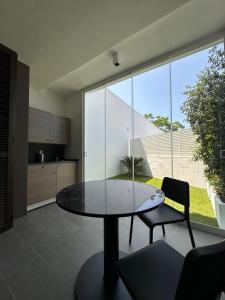a glass table and chairs in a room with a large window at Venus Suites in Bari