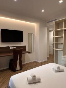a bedroom with a bed and a tv on the wall at Venus Suites in Bari