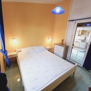 a bedroom with a large white bed in a room at Apartment in a house among three beaches in Sutomore