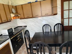 a kitchen with a table with chairs and a microwave at A Marosa playa in Burela de Cabo +17 photos