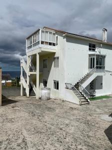 a white building with stairs on the side of it at A Marosa playa in Burela de Cabo