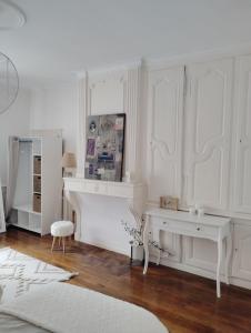 a white room with a desk and a table at La Maison d'Adèle in Neufchâteau +13 photos