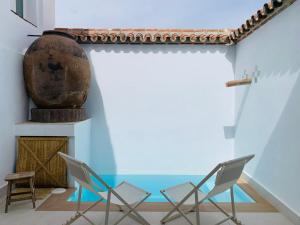 two chairs and a vase in a room at El Chorro del Granerillo in Cazalla de la Sierra