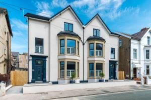 Casa blanca con puertas y ventanas azules en Mode Pleasure Beach Apartments, en Blackpool