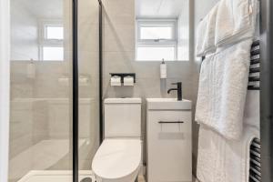 Un baño blanco con inodoro y ducha. en Mode Pleasure Beach Apartments, en Blackpool 63 fotos más
