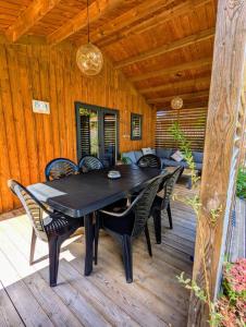 a black table and chairs on a wooden deck at Bassin d'Arcachon - Chalet VIP 5 personnes in La Teste-de-Buch