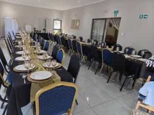 a row of tables and chairs in a room at LALA POA GUEST HOUSE in Klerksdorp