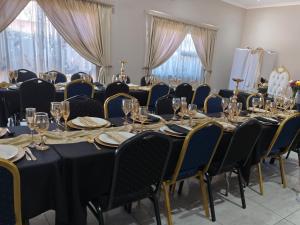 a conference room with tables and chairs with wine glasses at LALA POA GUEST HOUSE in Klerksdorp
