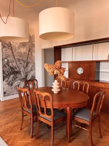 une salle à manger avec une table et des chaises en bois dans l'établissement Art Deco Retreat - Łódź Centrum, à Łódź