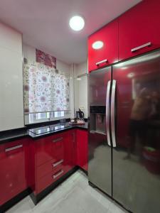 a kitchen with red cabinets and a stainless steel refrigerator at Magnífico alojamiento cerca de Mezquita catedral in Córdoba