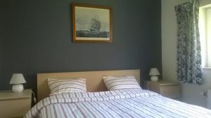 a bedroom with a bed and a picture on the wall at Au Phil des Saisons in Arbre