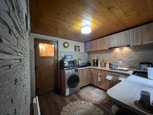 a small kitchen with a stove and a microwave at Villa Garden Balvanyos in Turia