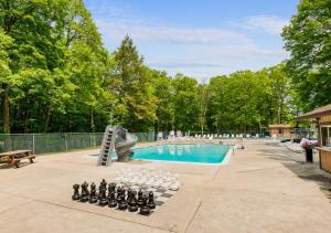 ein Schwimmbad mit einem Schachbrett vor einem Pool in der Unterkunft Dine Outdoors, Dream Indoors 5BR in East Stroudsburg