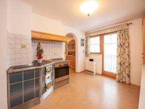 a large kitchen with a stove and a window at Apartment in Wald near Krimml Waterfalls in Wald im Pinzgau
