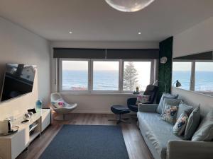 a living room with a couch and a television at Livelove Sea in Santa Cruz