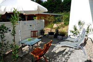 a patio with two chairs and a table and an umbrella at Holiday Apartment Sweden House in Lütjenburg