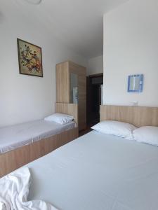 two beds in a room with white sheets at Accommodation Milla in Ulcinj