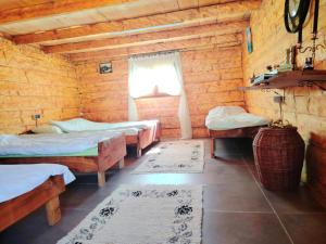 a room with three beds in a wooden cabin at CAMP Odmaraliste PURISIC in Plav
