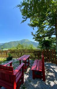 two red benches and a picnic table in front of a fence at Mountain Star House in Mojkovac