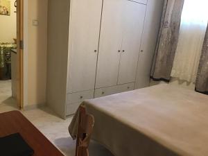 a room with a table and white cabinets in a room at Lidas Sunny Guest House Argolis in Nafplio
