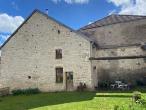a large brick building with a table in the yard at L'Epicerie in Melay