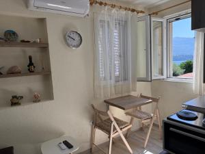 a kitchen with a table and a clock on the wall at Private double room in the Old Town in Budva +6 photos
