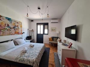 a bedroom with a bed and a living room at Cozy City Centar Studio in Podgorica