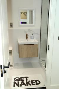 a bathroom with a sink and a shower and a rug at Jazreal Luxury Apartment - Leeds City Centre in Leeds
