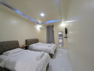 a hotel room with two beds and a tv at Din's Studio Homestay in Semporna