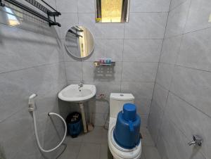 a bathroom with a sink and a toilet and a mirror at Din's Studio Homestay in Semporna