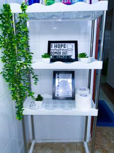 a shelf with potted plants and a sign on it at 1 Bedroom Apartment, Garden Estate,Nairobi in Nairobi +3 photos