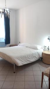 a bed in a bedroom with a white bedspread at Savelli House in Siena center with private parking and garden in Siena