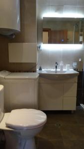 a bathroom with a white toilet and a sink at Апартамент Кабакум in Varna City