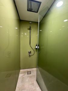 a bathroom with a shower with green walls at Sleep in the Sky KLCC View in Kuala Lumpur +10 photos