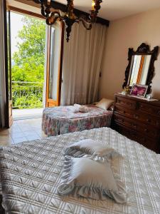 a bedroom with two beds and a dresser and a window at Il Giardino di Monterole Cà d'Pini in Bagnone