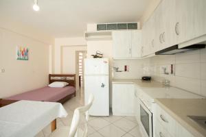 a kitchen with a white refrigerator and a table at Polichnitos Paradise Stay in Skála