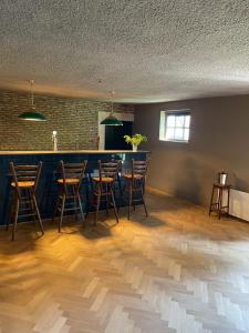 een kamer met een bar met stoelen en een tafel bij B&B Boudevino in Lekkerkerk +8 foto's