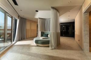 a bedroom with a green bed and large windows at Appartements Erzherzog Johann in Schladming